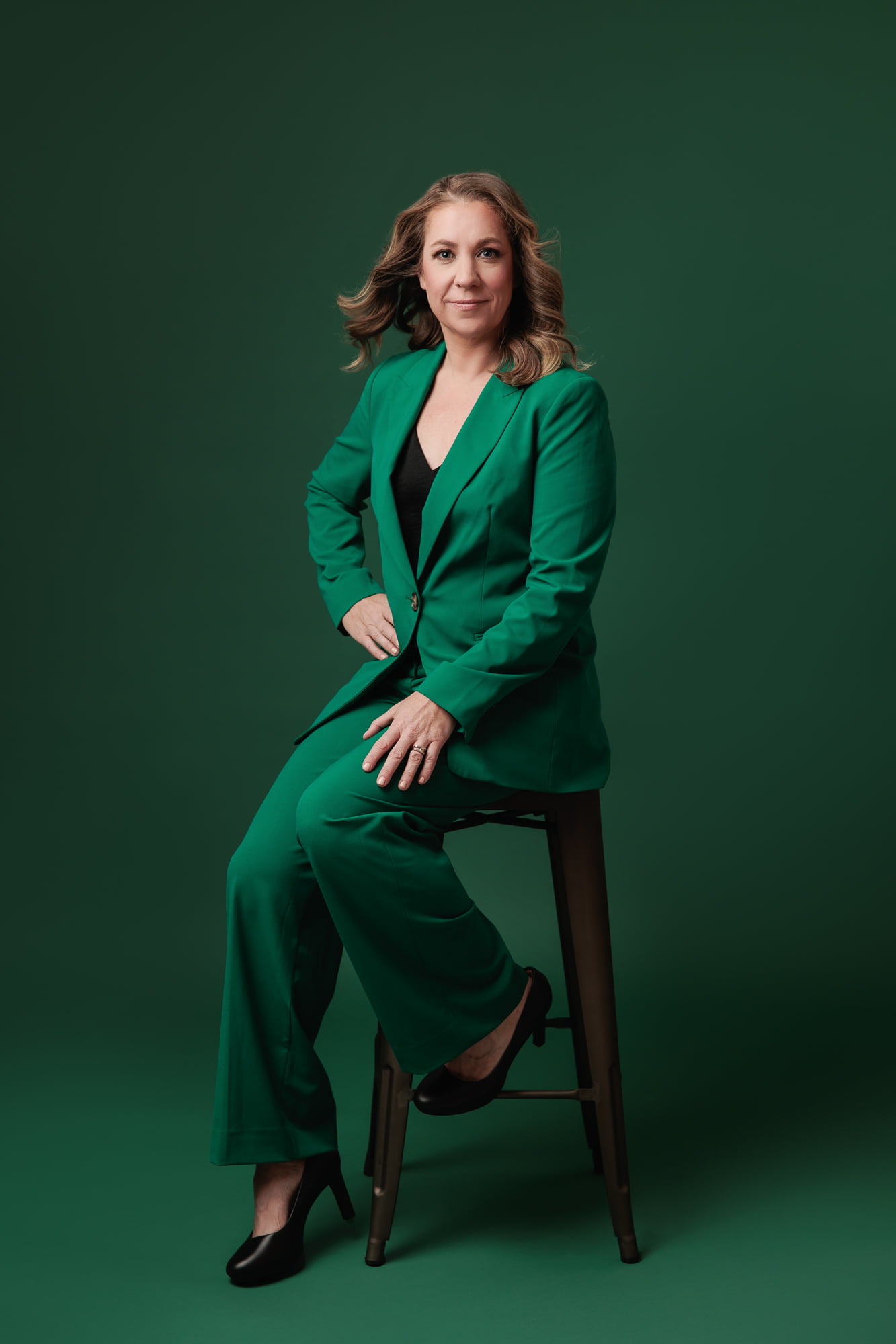calgary-photographers-amanda-dams-portraits-blonde-woman-sitting-on-stool-green-background-green-outfit